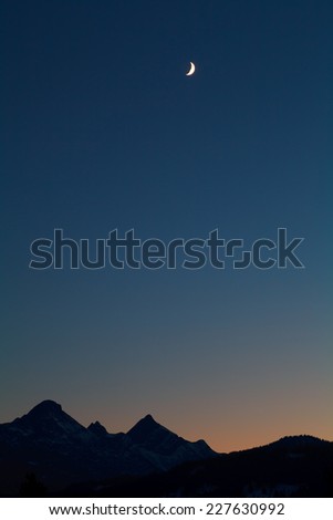 moon and mountain silhouettes over dark sky, Alps