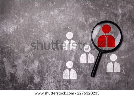 Magnifier placed on a cement floor, there is free space. Magnifier focuses on the leader or manager icon. Royalty-Free Stock Photo #2276320233