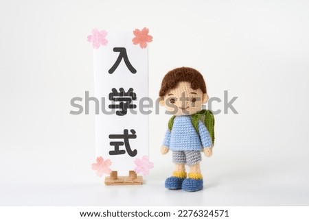 Small and cute Amigurumi doll on white background.　school (entrance ceremony in Japanese)