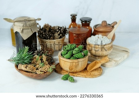 young green cones and flower pine pollen buds in bowls on table. Medicinal plants of folk medicine containing vitamin C, used for the treatment of colds, strengthening immunity. spring seasonal plants Royalty-Free Stock Photo #2276330365