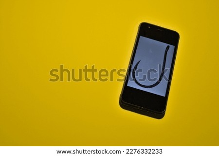 Smartphone with phishing scam sign on internet mail 
e-mail on yellow background copy space