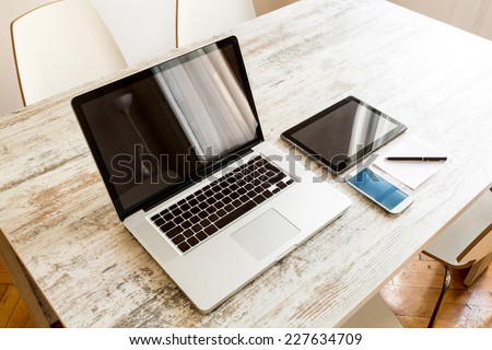 A Laptop computer, a Tablet PC and a Smartphone on a Desktop.  Royalty-Free Stock Photo #227634709