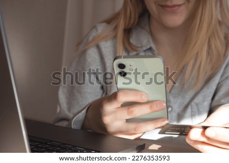 Woman hands holding plastic credit card and using laptop. Online shopping or payment concept. Toned picture. High quality photo with girl smile