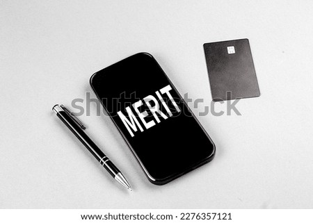 MERIT word on a smartphone with credit card and pen