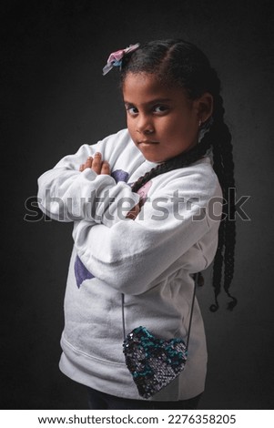 Very angry African American girl looking at the camera posing on a black background. High quality photo