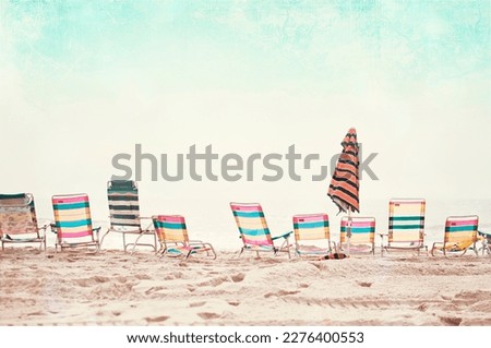 A bunch of colorful beach chairs, everyone is in the ocean.  Vacation photography.