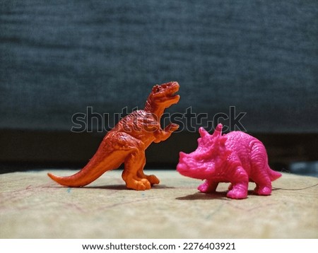 toy-shaped replicas of Tyrannosaurus Rex and Triceratops