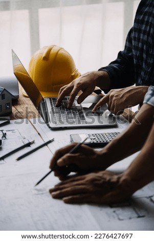 Construction and structure concept of engineer working drawing on blueprint meeting for project working with partner on model building and engineering tools in working site, construction concept Royalty-Free Stock Photo #2276427697