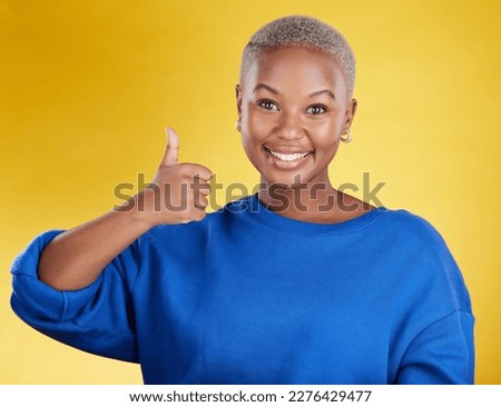 Portrait, smile and black woman with thumbs up in studio isolated on a yellow background. Success, emoji face and happy African female with hand gesture for agreement, support or approval, like or ok