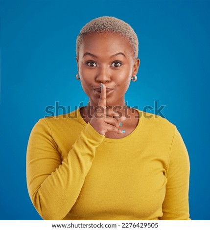 Shush, secret and portrait of black woman in studio for secret, announcement and news. Silence, mystery and privacy with female isolated on blue background for rumor, gossip and confidential Royalty-Free Stock Photo #2276429505