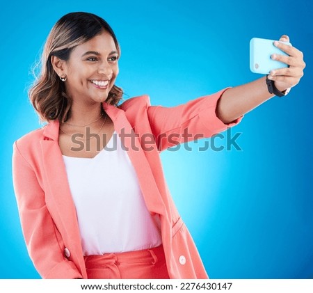 Selfie, smile and business woman in studio isolated on a blue background. Photographer, professional and Indian female entrepreneur taking photo for happy memory, social media and profile picture.