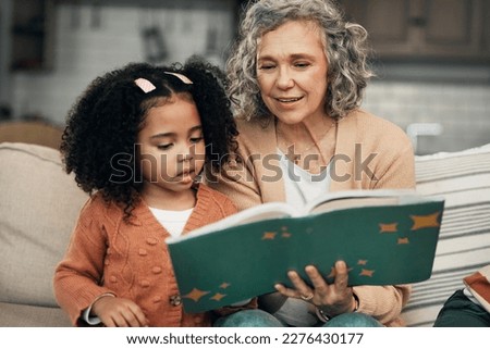 Adoption child, book and grandmother reading fantasy storybook, story or bonding on home living room sofa. Family love, grandma and senior woman with youth development for learning kindergarten girl Royalty-Free Stock Photo #2276430177