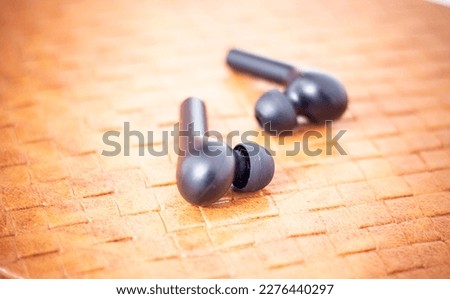 Close-up wireless headphones lie on a textured background.