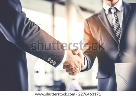 Businessman shaking hands after signing off on a meeting with partners, setting goals, and planning the way to success. Collaborative teamwork. Royalty-Free Stock Photo #2276463171