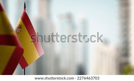Small flags of the Spain on an abstract blurry background. Royalty-Free Stock Photo #2276463703