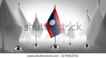 The national flag of the Laos surrounded by white flags.