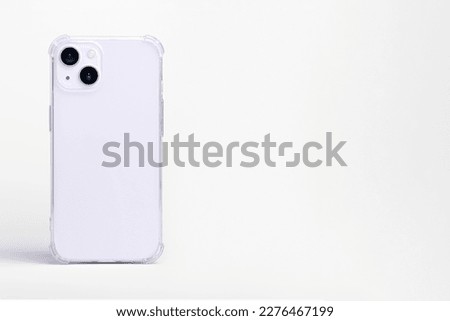purple iPhone 14 in clear transparent soft silicone case back view. Phone case mockup isolated on gray background. Banner with place for text on the right