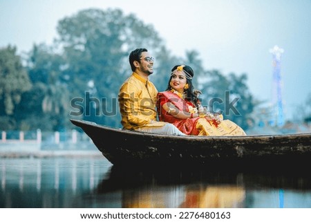 A beautiful happy indian bride and groom in the boat. a  indian bride and groom in traditional wedding dresses. Royalty-Free Stock Photo #2276480163