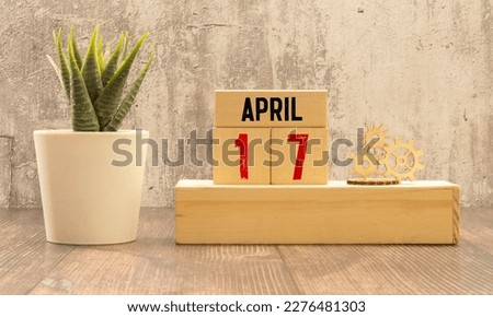 April 17 calendar date text on wooden blocks with blurred park background. Copy space and calendar concept.