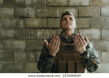 A Muslim soldier of the special forces prays to God by raising his hands and starts a prayer