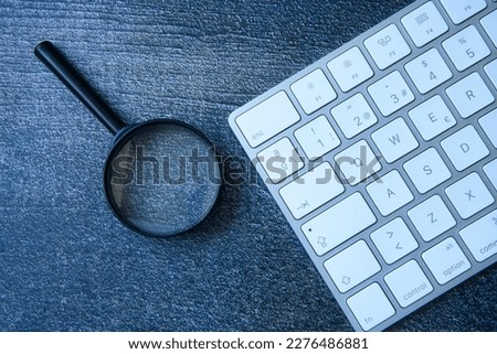 the magnifying glass and keyboard are the perfect combination as a concept in the search of right keywords that will improve your website's search engine ranking. Royalty-Free Stock Photo #2276486881