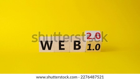WEB 2 or 1 symbol. Turned wooden cubes with words WEB 1.0 or WEB 2.0. Beautiful yellow background. Business and WEB concept. Copy space