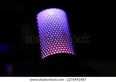 Purple LED Lighted Podcast Microphone on Desk With Dark Black Background