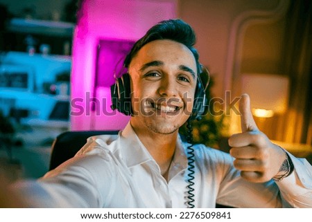 Self portrait of one man caucasian male streamer blogger or content creator with headphones on his head happy smile confident in his studio copy space user generated content UGC Royalty-Free Stock Photo #2276509841
