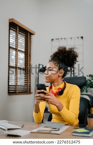 Using cellphone, Young female african american woman working with financial statement at home, housewife manage family budget concept