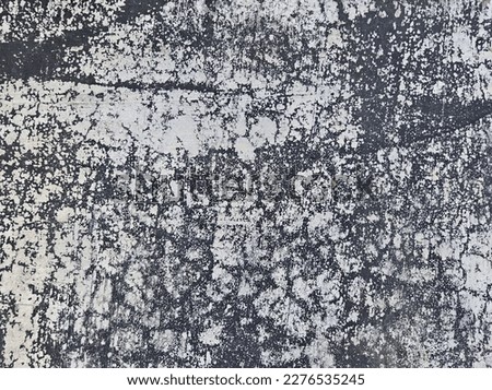 The surface of the cement wall with the paint peeling off from long-term use. 