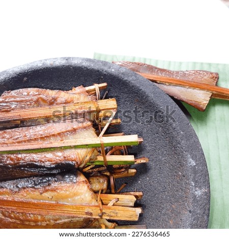 Close up of Smoked fish. Smoked stringry on mortar stone against white background. Fresh. Smoked stringray fillet of Fillet fish. Seafood. Isolate.  Royalty-Free Stock Photo #2276536465