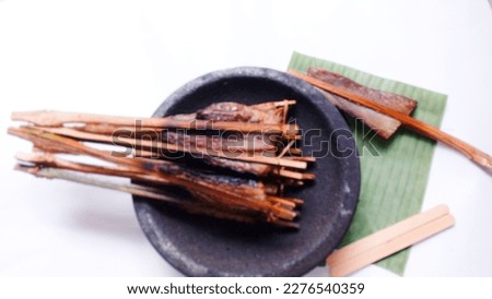 De focused of  Smoked fish. Smoked stringray on mortar stone against white background. Fresh. Smoked stringray fillet of Fillet fish. Seafood. Isolate.  Royalty-Free Stock Photo #2276540359