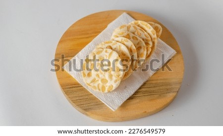 Indonesian Snack Round Tempe Chips on Wooden Board Royalty-Free Stock Photo #2276549579