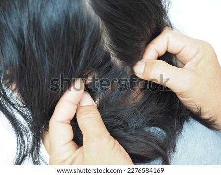 Mother find lice, cleaning the hair on the head by hands. Lice removal product concept. Closeup photo, blurred.
