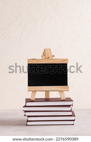 black board for text on stack of books on white background. copy space. Education and exhibitions, meetings concept. Back to school