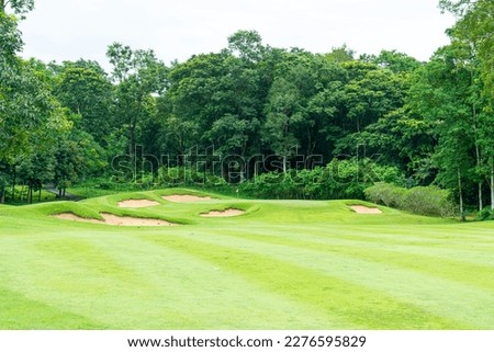 Green and Sand bunkers on Golf course with mountain hill background