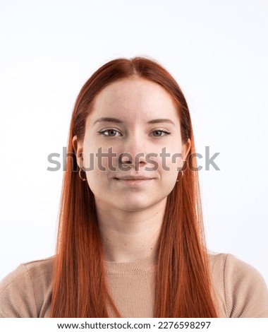 Passport photo of a real young woman with ginger red hair , isolated on white background. Document photo