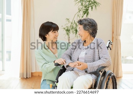 Senior woman in wheelchair indoors with grandson Royalty-Free Stock Photo #2276614697