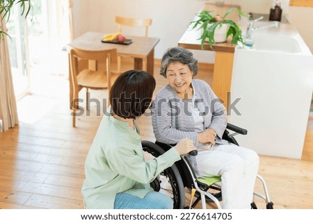 Senior woman in wheelchair indoors with grandson