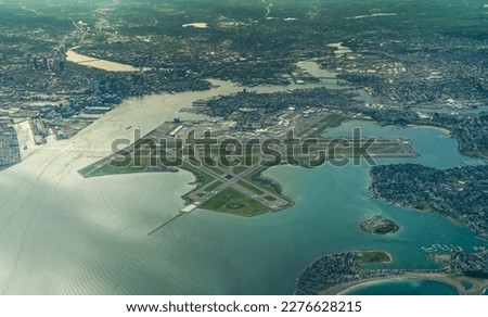 aerial landscape view of "Edward Lawrence Logan International Airport" with runway environment and the City of Boston MA in the background