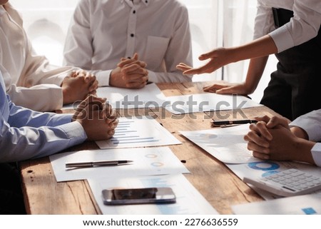 Teamwork with businessman analyzing cost graphs on table at conference room. Royalty-Free Stock Photo #2276636559