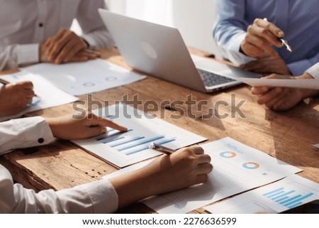 Teamwork with businessman analyzing cost graphs on table at conference room.