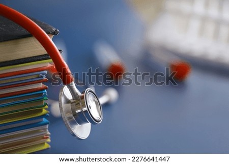 stethoscope on stack of medical guide book for doctor learning treatment hospital.