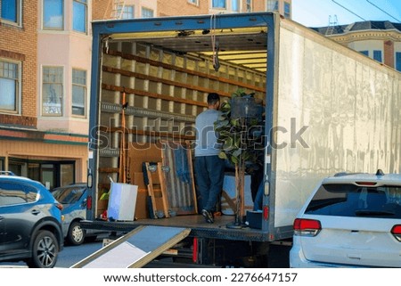 On moving day with truck for transporting house goods and furniture with delivery service using dolly inside home Royalty-Free Stock Photo #2276647157