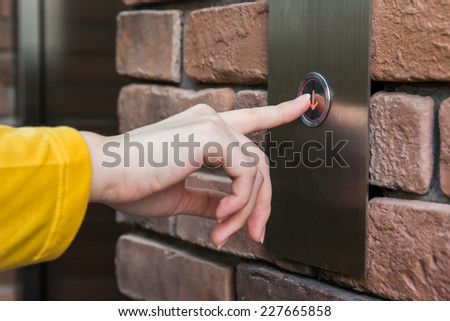 Young woman pressing elevator button