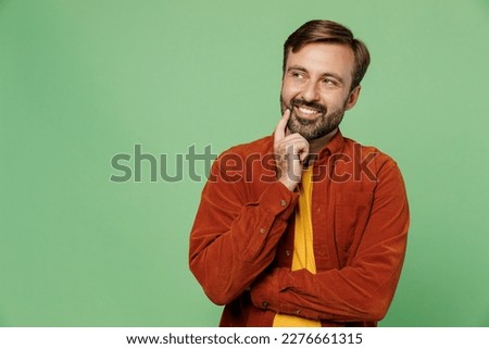 Elderly man 40s years old he wears casual clothes red shirt t-shirt put hand prop up on chin, lost in thought and conjectures look aside isolated on plain pastel light green background studio portrait