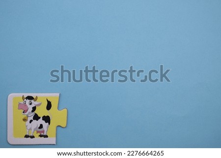 Cow picture jigsaw, Cow picture jigsaw placed on the left over blue background.
