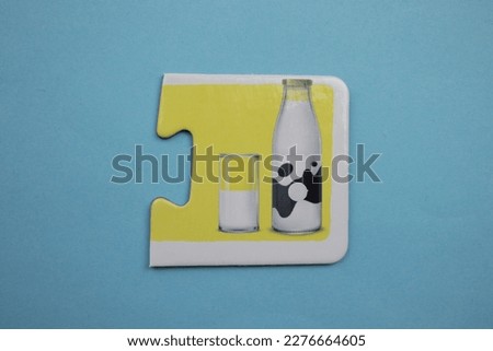 milk bottle picture jigsaw, milk bottle picture jigsaw placed on a blue background.