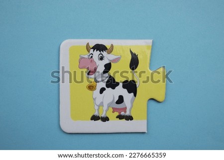 Cow picture jigsaw, Cow picture jigsaw placed over blue background.