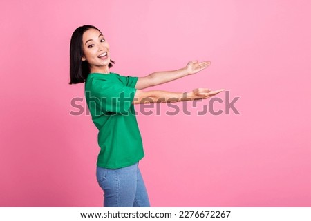 Side profile photo of optimistic nice girl with bob hairdo wear green t-shirt demonstrate empty space isolated on pink color background